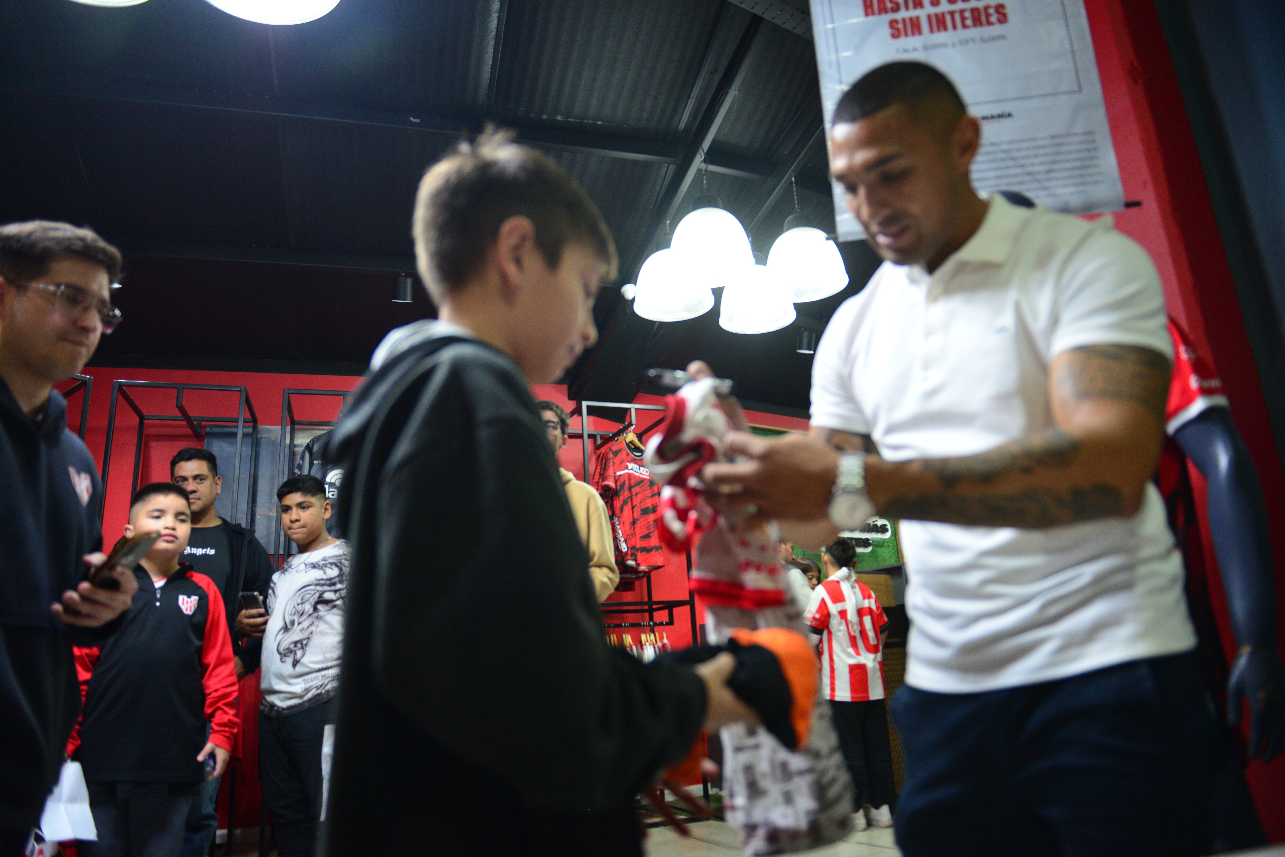 Fernando Alarcón jugador de Instituto en la sede del club firmando remeras