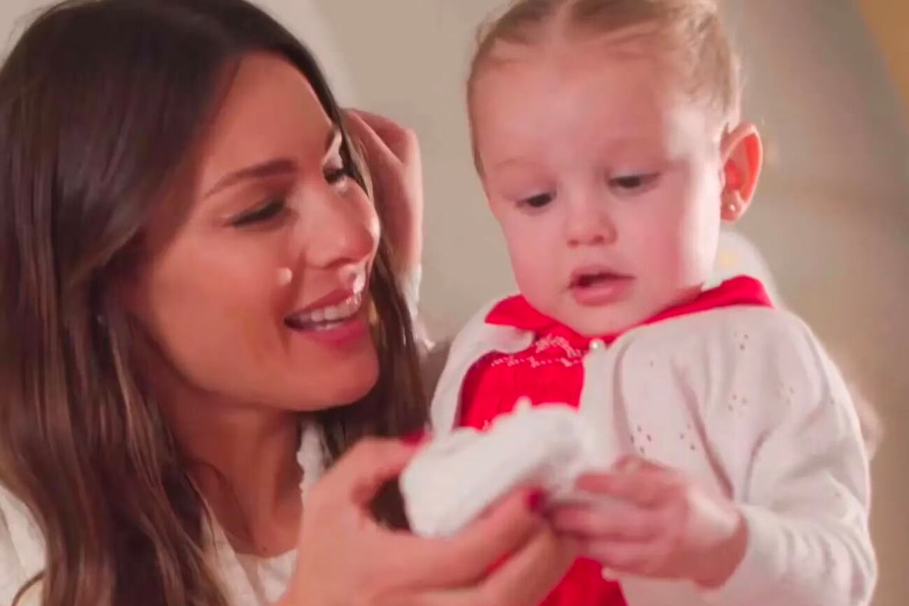 Pampita le muestra a su hija Ana unos escarpines.