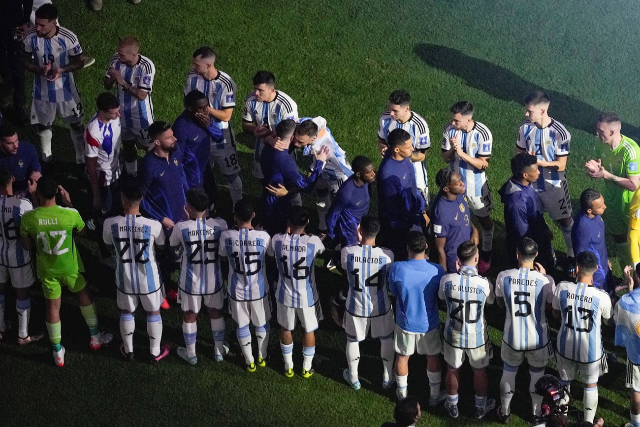 Los jugadores de Francia caminan hacia el podio a recibir sus medallas de plata del Mundial de Qatar, envueltos en aplausos de los campeones argentinos. Foto: AP.