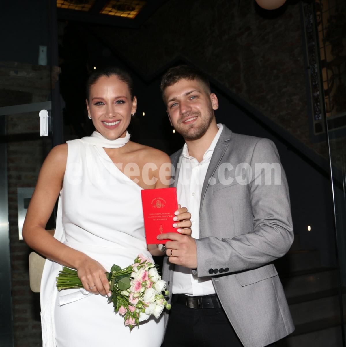 Los novios posando con la libreta minutos después de dar el sí.