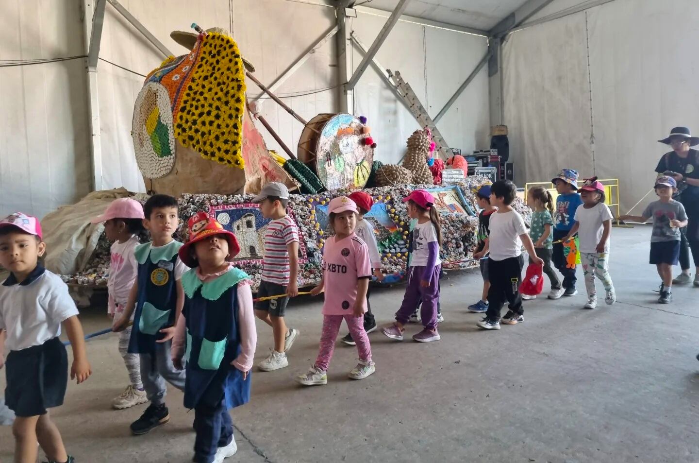 Mientras las carrozas estudiantiles aguardan el momento de salir al circuito, escolares de la ciudad las visitan en el sector de parque cerrado.