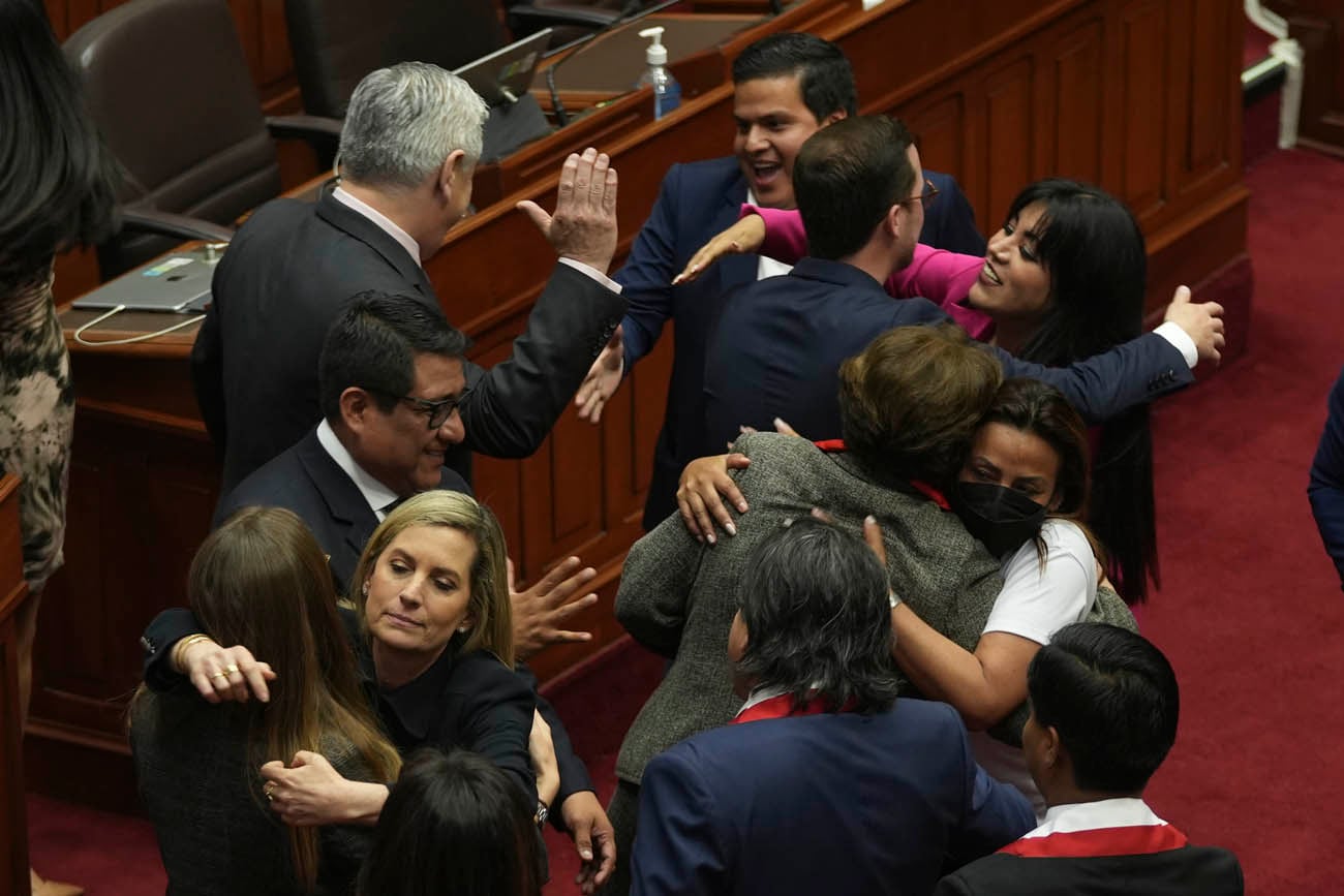 Los legisladores celebran después de votar verbalmente para destituir al presidente Pedro Castillo.