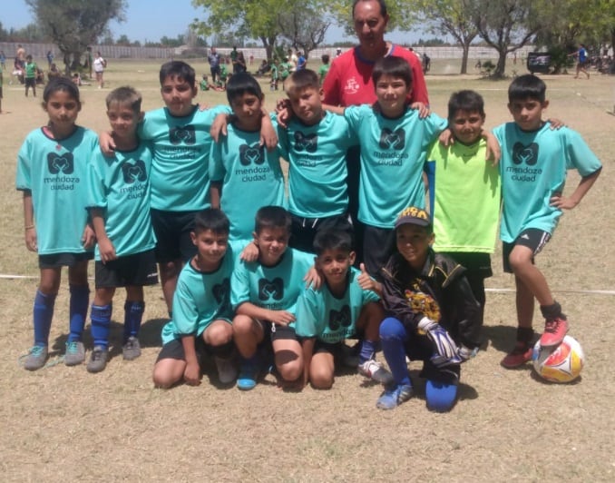 Juan arce junto a una de las categorías de fútbol del barrio La Favorita.