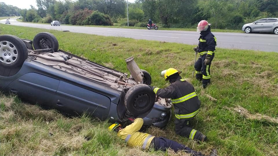 Bomberos y policías asistieron a la mujer tras el vuelco en autopista.