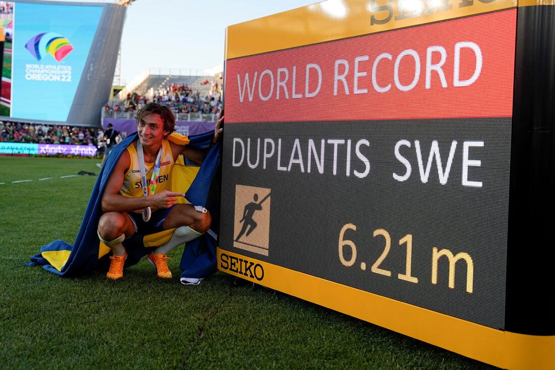 Armand Duplantis, enfundado en los colores de su país, muestra orgulloso el récord mundial de salto con garrocha que estableció en Eugene. (AP)