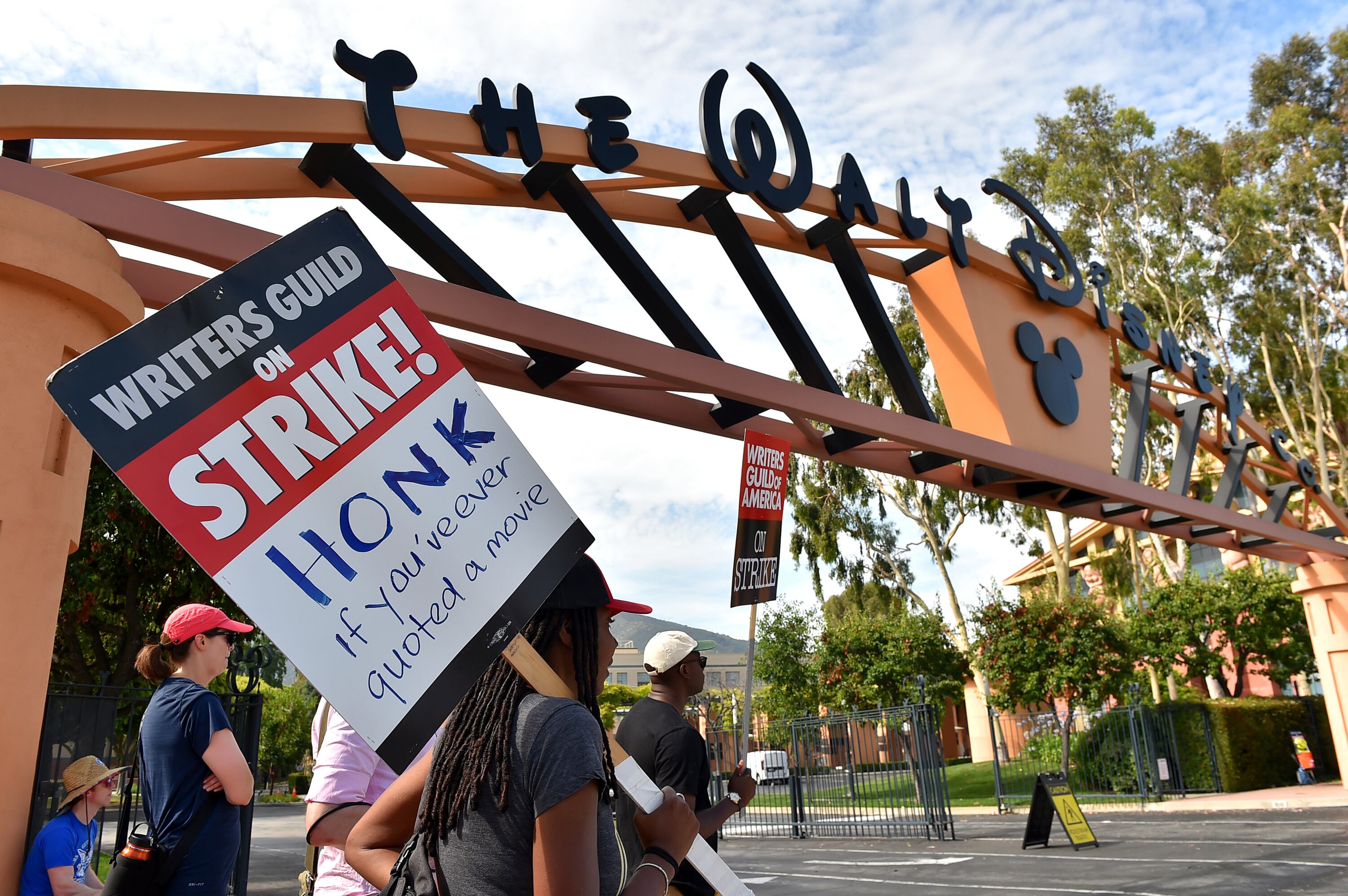 Manifestantes con carteles fuera de los estudios de Disney el lunes 17 de julio de 2023 en Burbank, California. La huelga de actores se produce más de dos meses después de que los guionistas comenzaran a hacer huelga en su intento por obtener mejores salarios y condiciones laborales y tener pautas claras sobre el uso de inteligencia artificial en producciones de cine y televisión.(Jordan Strauss/Invision/AP)