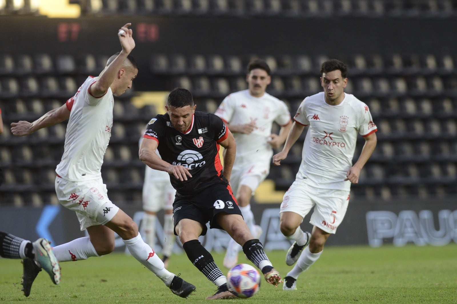 Rodeado. Adrián Martínez, a quien el miércoles casi ni le llegaron pelotas para definir, intenta entre varios jugadores de Huracán, que ganó y se clasificó a octavos de final. (Télam)