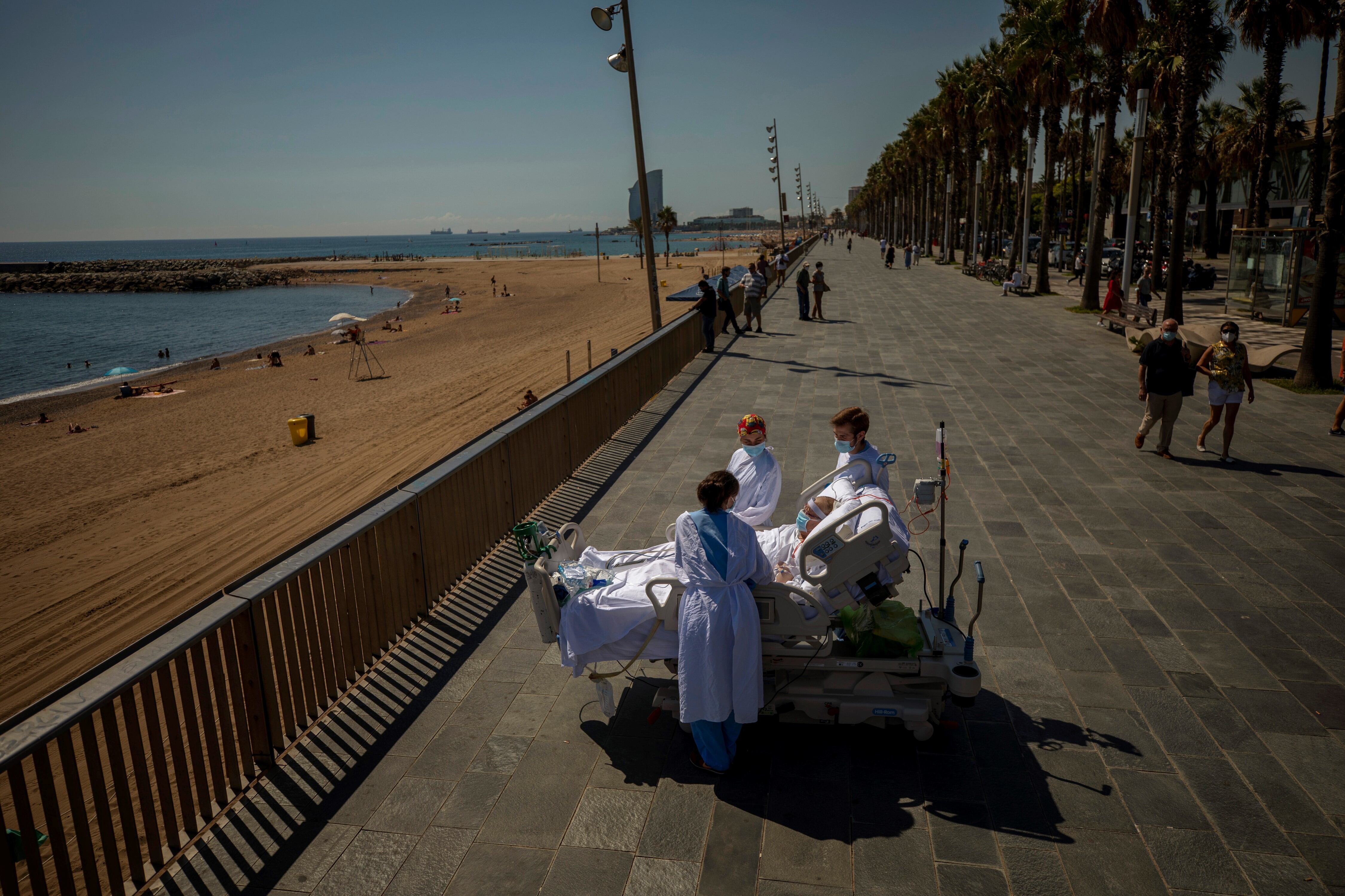 Francisco España, de 60 años, está rodeado por miembros de su equipo médico mientras observa el mar Mediterráneo desde un paseo junto al "Hospital del Mar" en Barcelona, ​​España, el viernes 4 de septiembre de 2020. Emilio Morenatti/AP