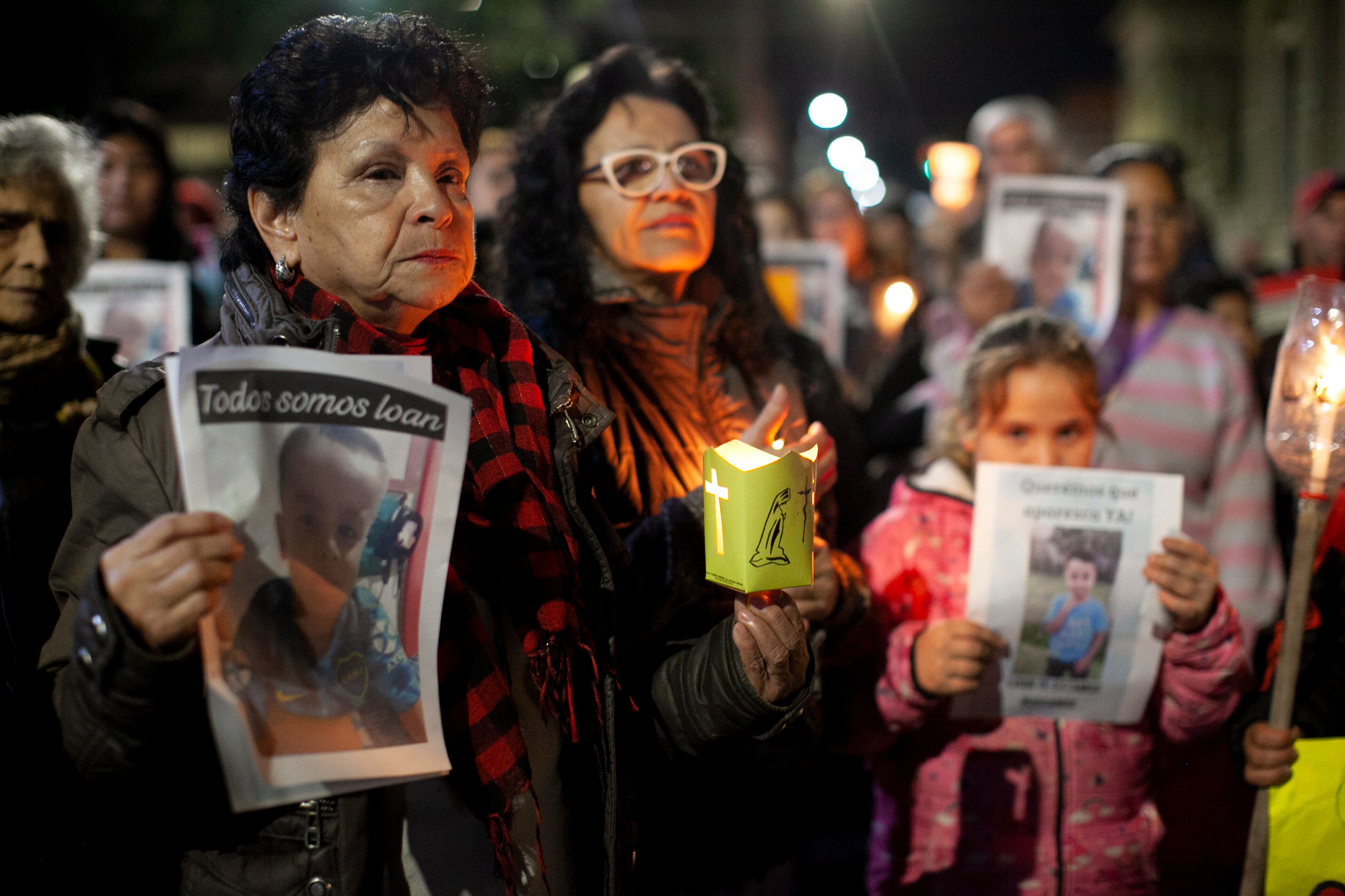 Manifestantes sostienen fotografías del niño Loan Danilo Peña el lunes 24 de junio de 2024, en Corrientes, Argentina. El pequeño de 5 años desapareció cerca del pueblo 9 de Julio, provincia de Corrientes. (AP Foto/Joaquín Meabe)