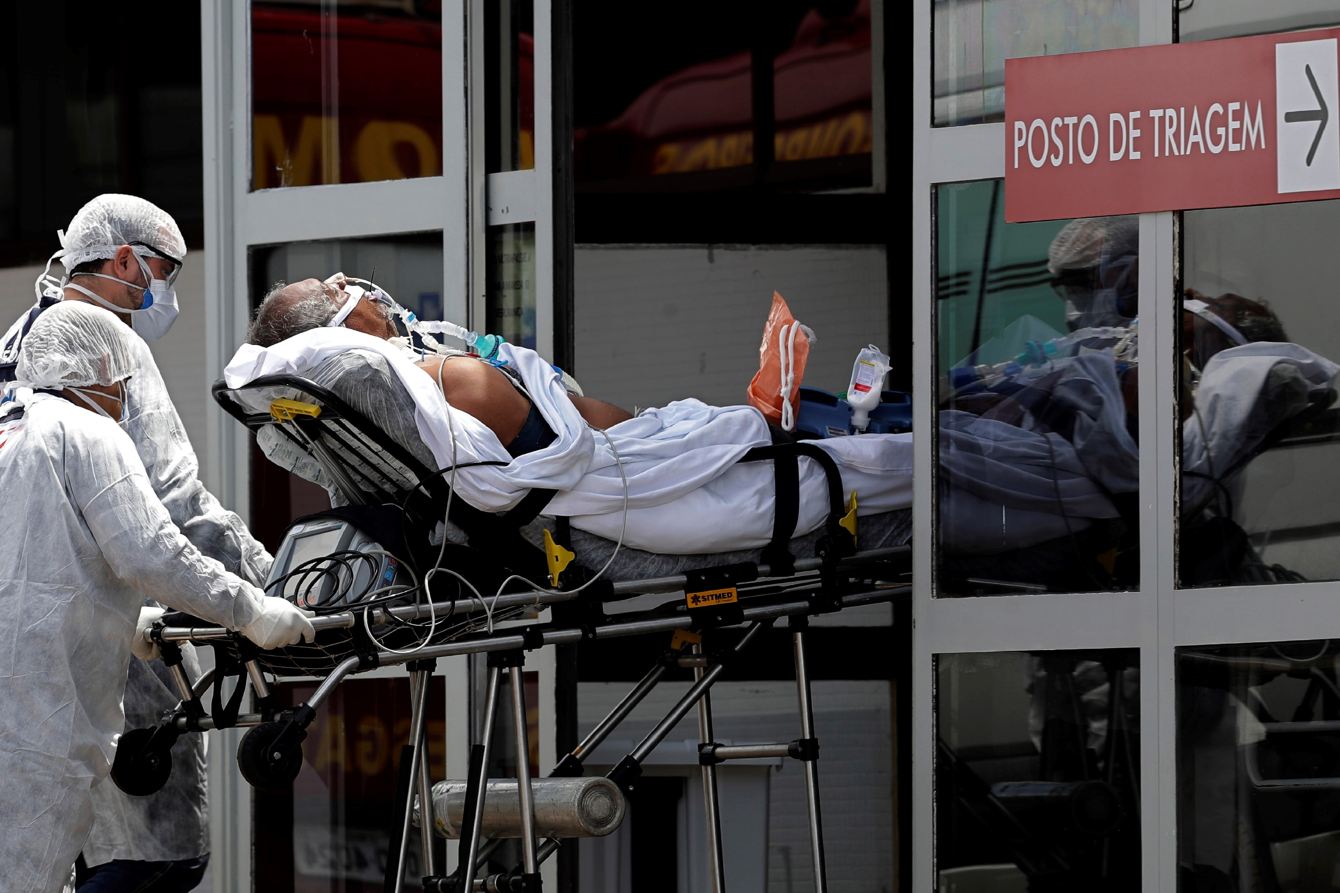 Los trabajadores de la salud llevan en una camilla a un paciente sospechoso de tener COVID-19 desde una ambulancia al hospital público HRAN en Brasilia, Brasil. Foto: AP