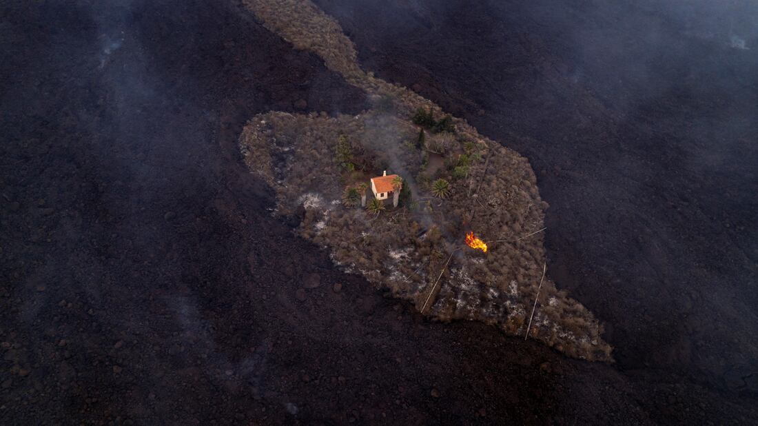 Una casa permanece intacta mientras la lava fluye a su alrededor . (AP)