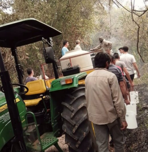 Productores, policía y personal de la municipalidad de Loreto ayudando a vecinos frente al fuego.