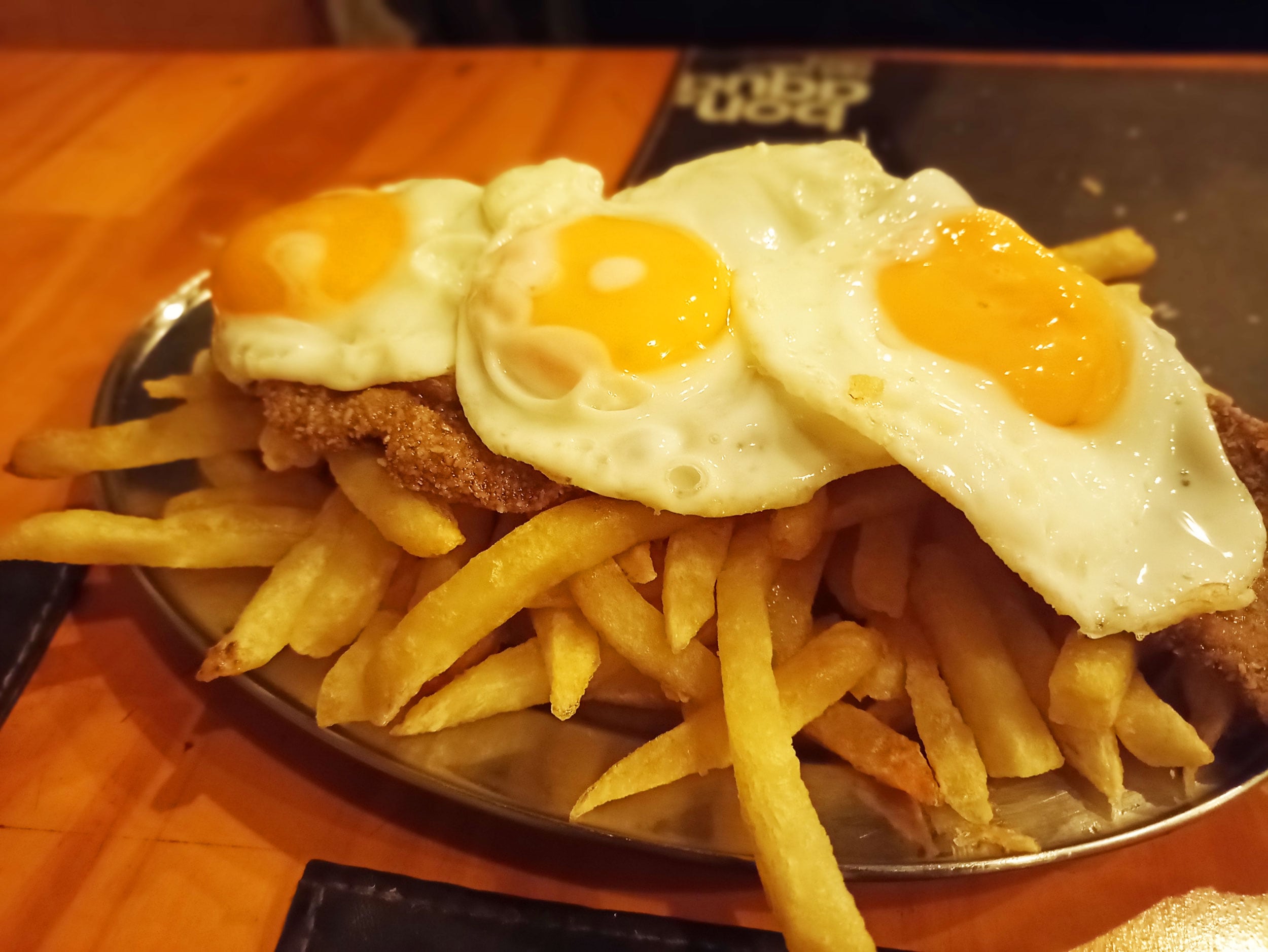 Milanesas con huevo y papas fritas.