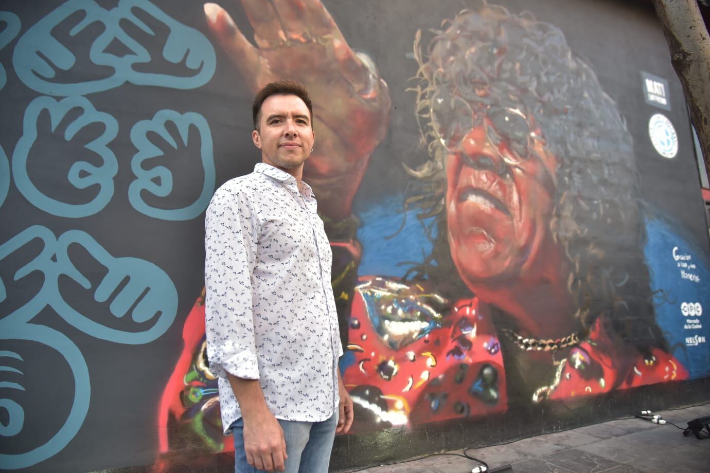 Matías Loffredo junto al mural de La Mona Jiménez en Alberdi.