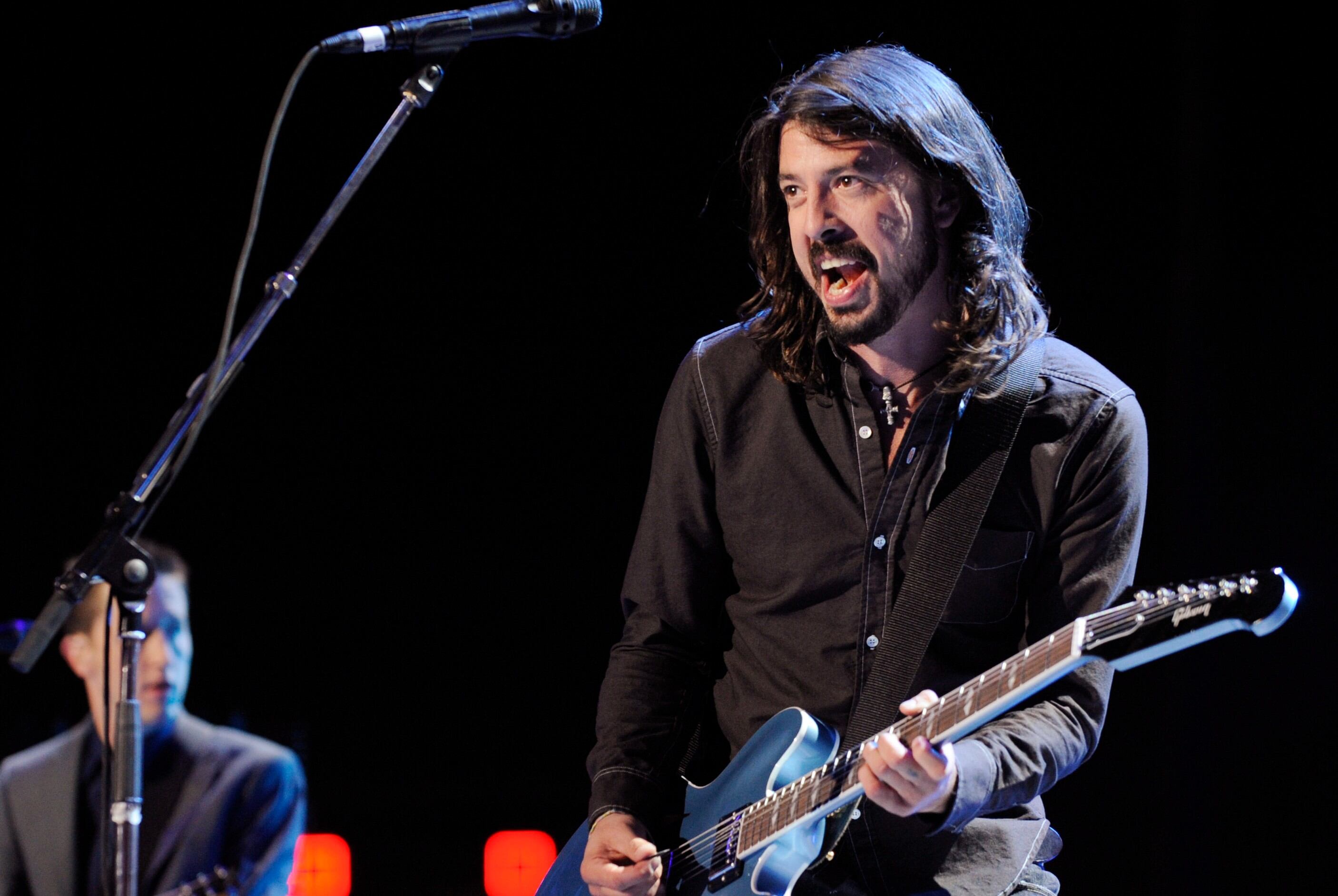 Dave Grohl, con gesto gozoso durante un show de Foo Fighters. (AP)