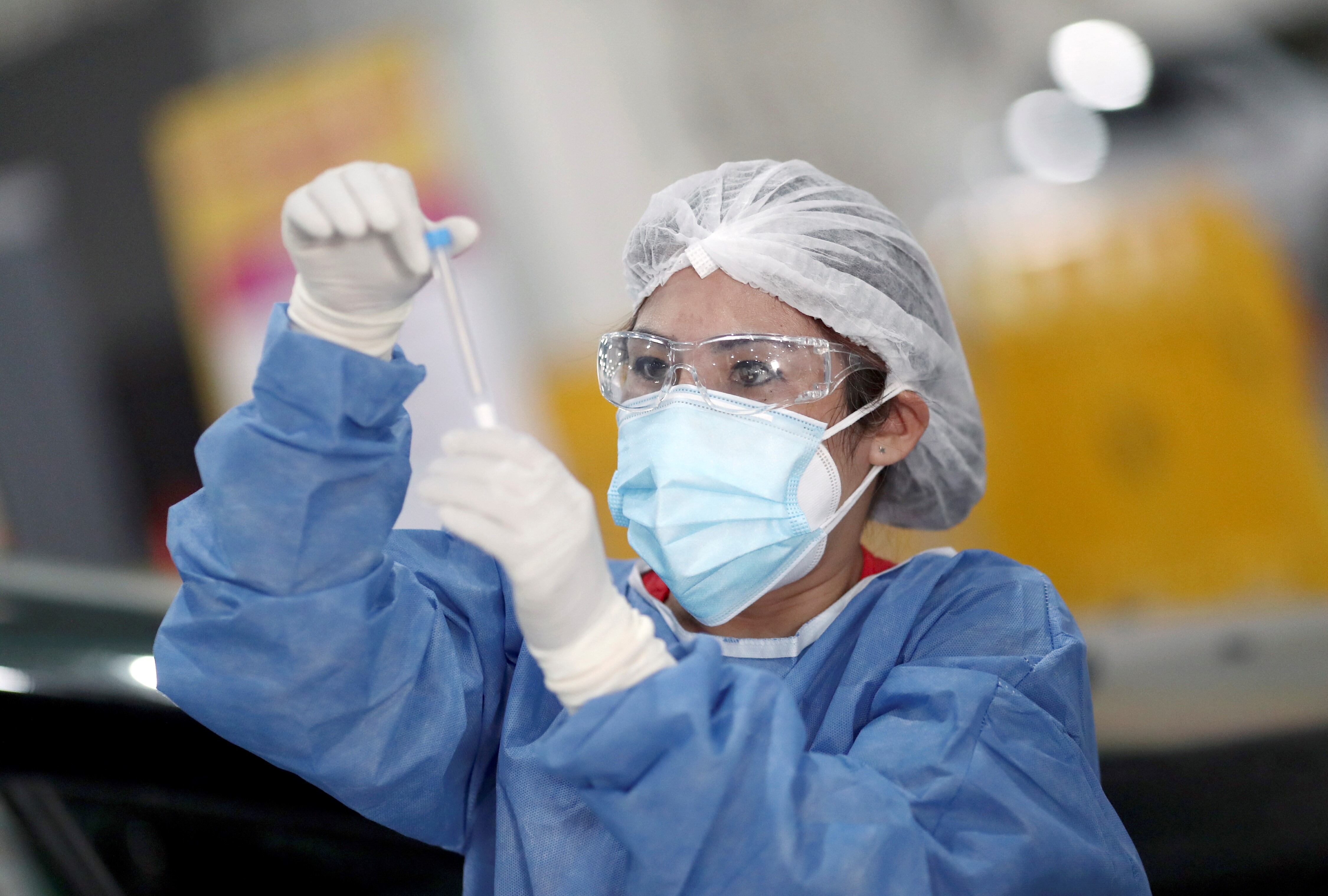 Una trabajadora de la salud sostiene un hisopado de coronavirus en Buenos Aires. (Foto: Agustin Marcarian)