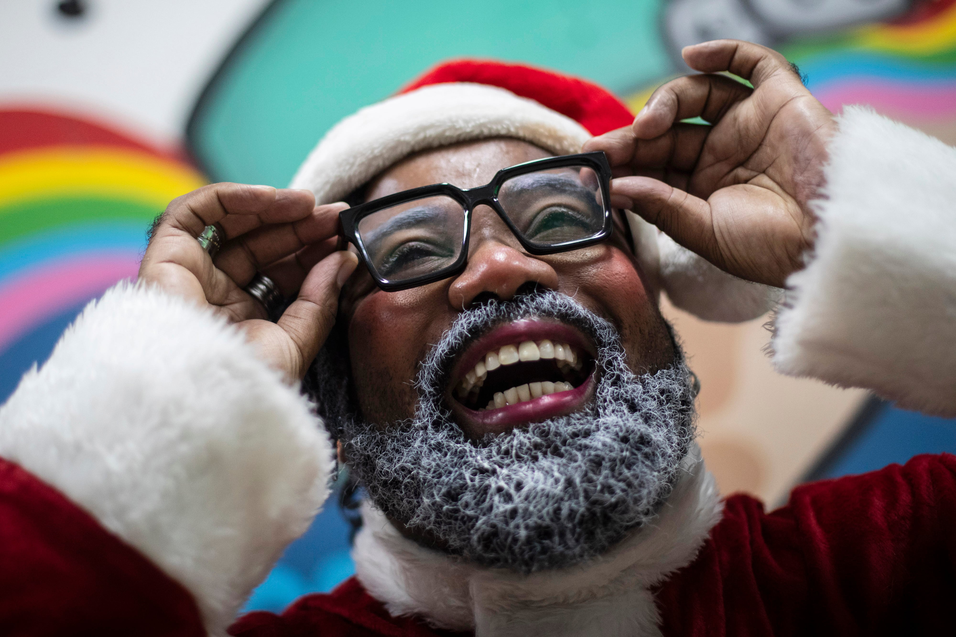 Rodrigo Franca se prepara para su papel como "Papai Negro" o Santa Claus Negro, durante un evento de Navidad en una escuela en la favela Cidade de Deus, en Río de Janeiro, Brasil, el 11 de diciembre de 2023. (AP Foto/Bruna Prado)