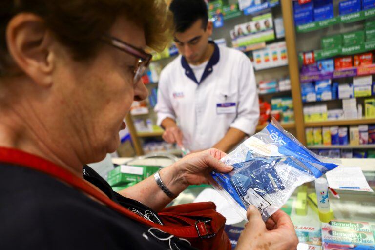 Una mujer compra un barbijo (REUTERS/Matias Baglietto)