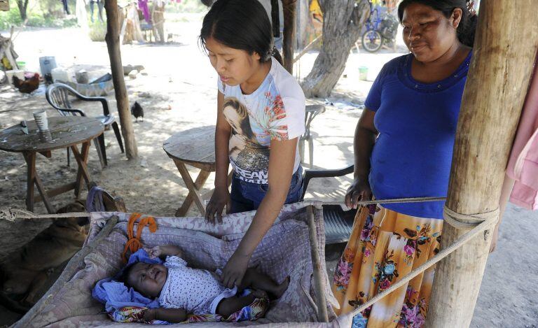 Una mujer atiende a su hijo en la comunidad wichí de San Luis, ubicada en un recodo del río Pilcomayo en el extremo noreste de Salta, en diciembre de 2016. TELAM