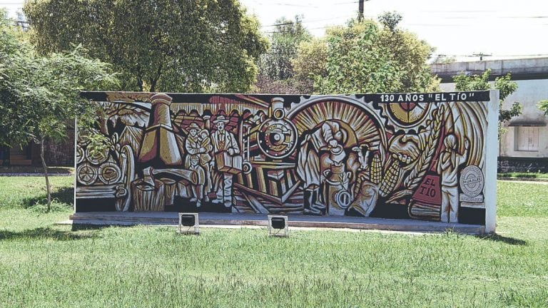 Mural conmemorativo del 130° aniversario de El Tío. Con técnicas de pintura bajo relieve se reflejan los orígenes e historia de la localidad: la llegada de los inmigrantes, los aserraderos, el tren, la agricultura y ganadería, la chimenea y la fraternidad. (Gentileza Yohana Semperez)