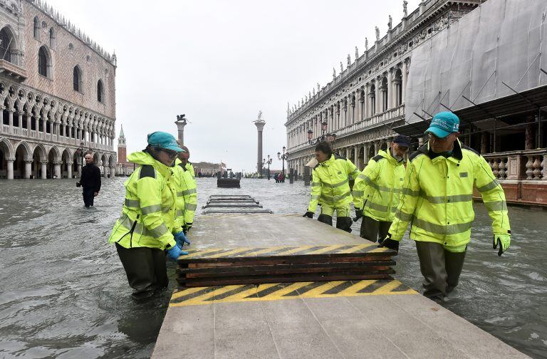 Los trabajadores desmantelan una pasarela improvisada sobre la inundada Plaza de San Marcos. Crédito: REUTERS / Flavio Lo Scalzo.