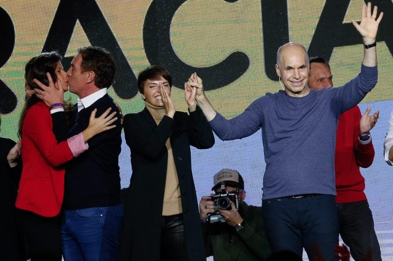 El jefe de Gobierno, Horacio Rodríguez Larreta, saluda junto a su esposa Bárbara Diez, mientras su vice, Diego Santilli, besa a su esposa Analía Maiorana, tras las elecciones primarias. Crédito: EFE/ Juan Ignacio Roncoroni.