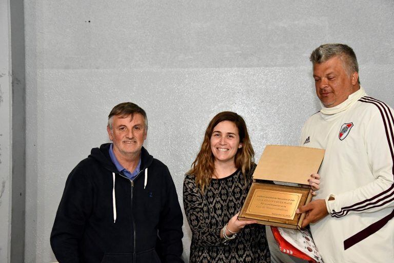 Jimena López y Miguel Arana entregando un presente al Club River