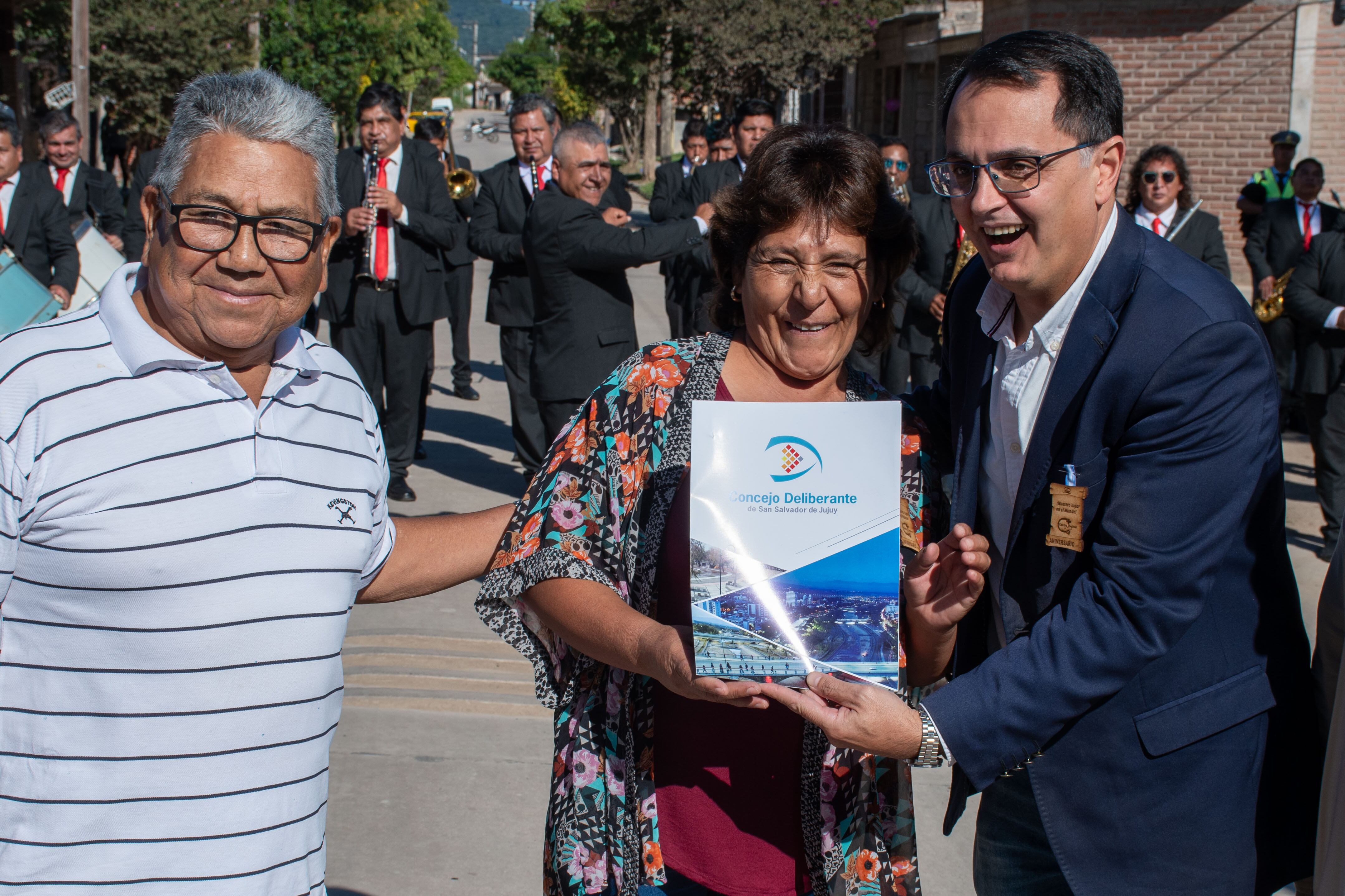 El presidente del Concejo Deliberante de San Salvador de Jujuy, Lisandro Aguiar (derecha), entrega a dirigentes del barrio ATSA la declaración "de interés" por la celebración.