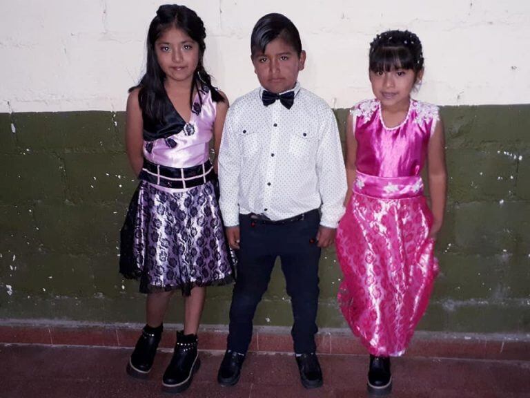 Bairon junto a dos niñas peinadas por él.