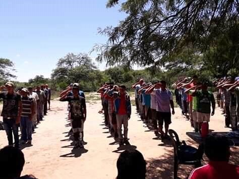 Integrantes de la "Guardia Wichí" formados en fila y realizando la venia militar.