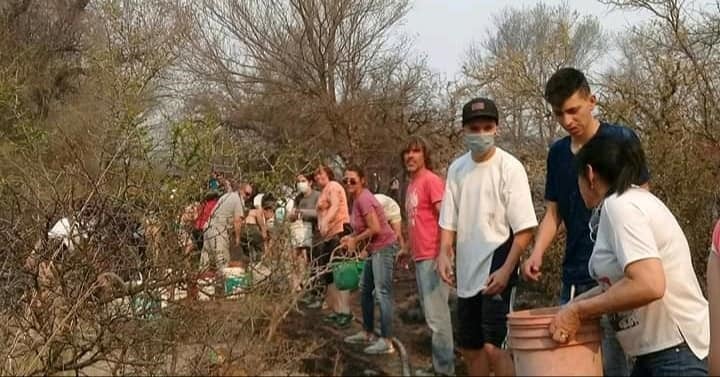 En Mina Clavero se formó un corredor humano de acarreo de agua para combatir los incendios. (Belen Intima)