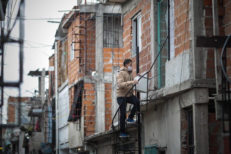 AME7712. BUENOS AIRES (ARGENTINA), 05/05/2020.- Un hombre es visto con tapabocas mientras entra a una casa al interior del barrio Villa 31 hoy martes, luego del crecimiento de los casos detectados de COVID-19 en barrios populares de la ciudad de Buenos Aires (Argentina). EFE/Juan Ignacio roncoroni