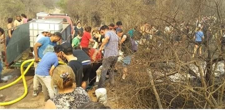 En Mina Clavero se formó un corredor humano de acarreo de agua para combatir los incendios. (Belen Intima)