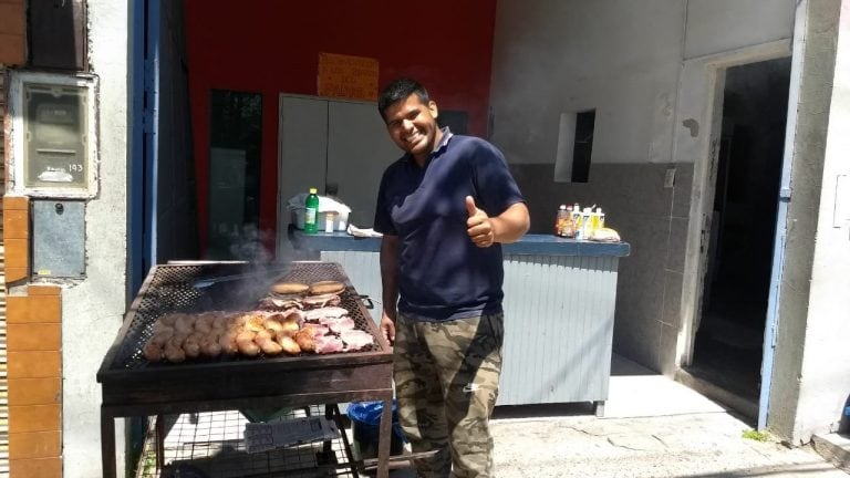 Choripanero e hinchas que ven el clásico desde la casa pegada al estadio