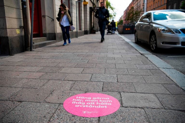 "Siéntete libre de pasar el rato aquí, pero recuerda mantener tu distancia", dice un sticker pegado en las calles de Estocolomo. (AFP)