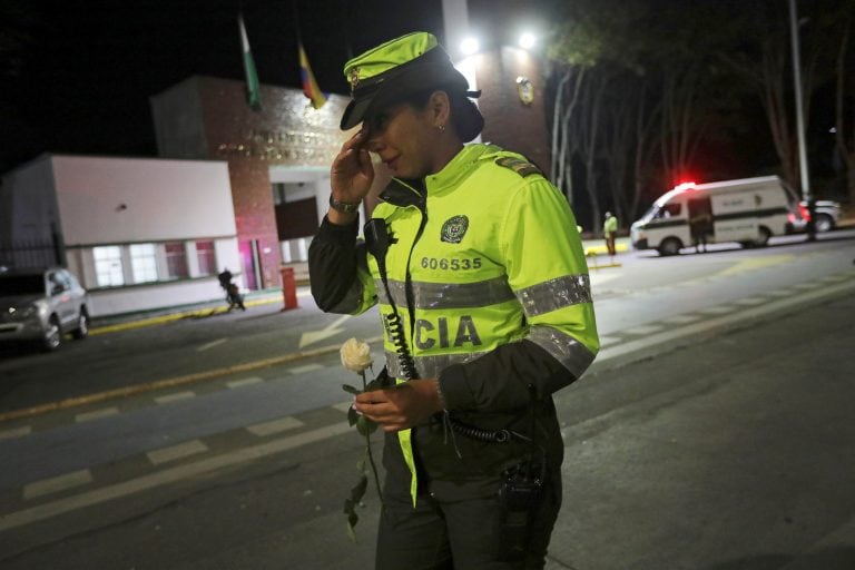 Dolor en la fuerza por las víctimas. Una oficial de policía, entre lágrimas, ofrece una rosa.