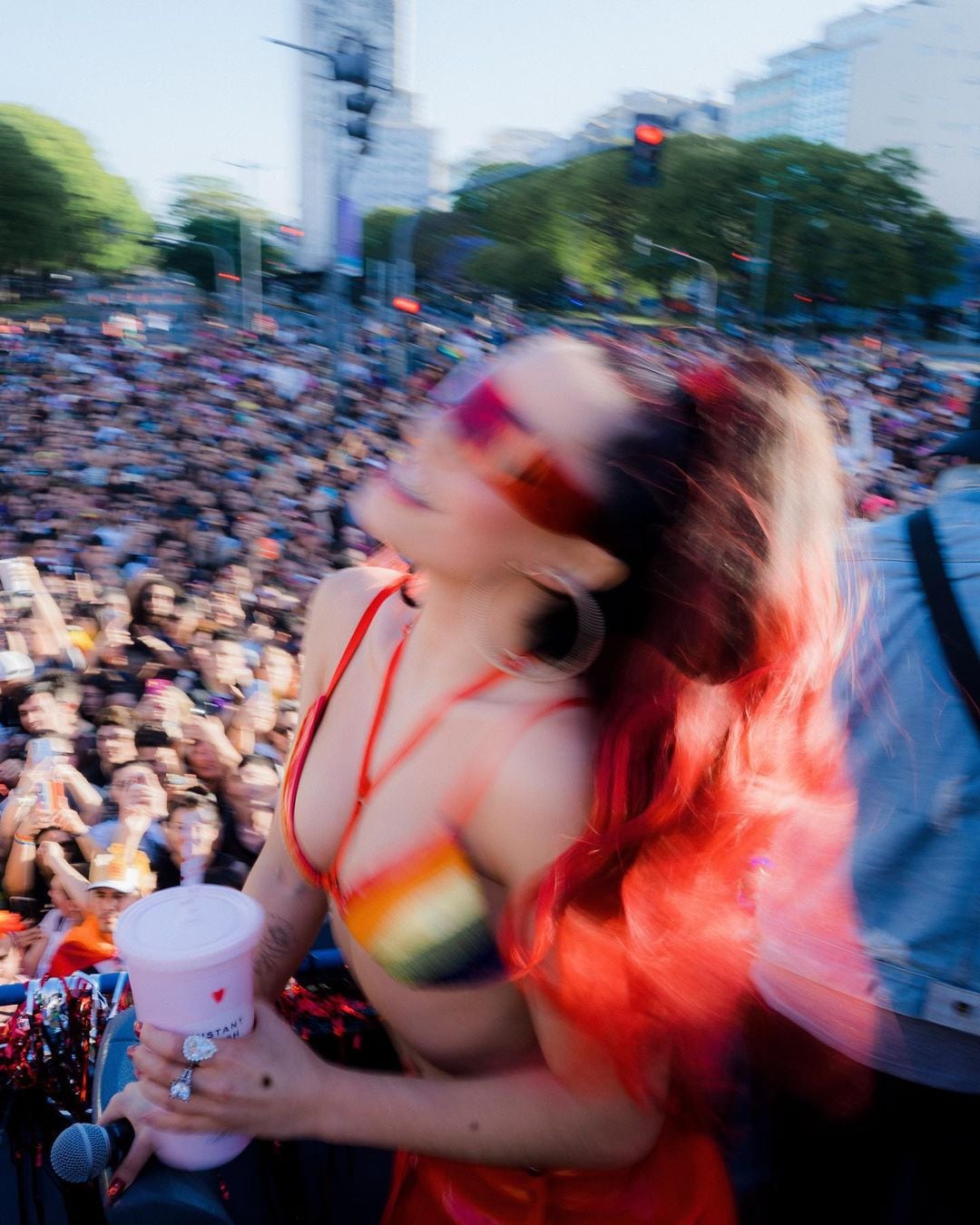 Mechas rojas, corpiño de colores y pantalón engomado: el look de Lali con el que deslumbró en la Marcha del Orgullo.