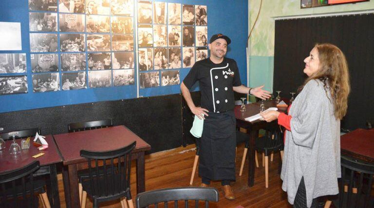 Diego conversa con Vía Santa Rosa junto a una pared con fotografías (Vía Santa Rosa)