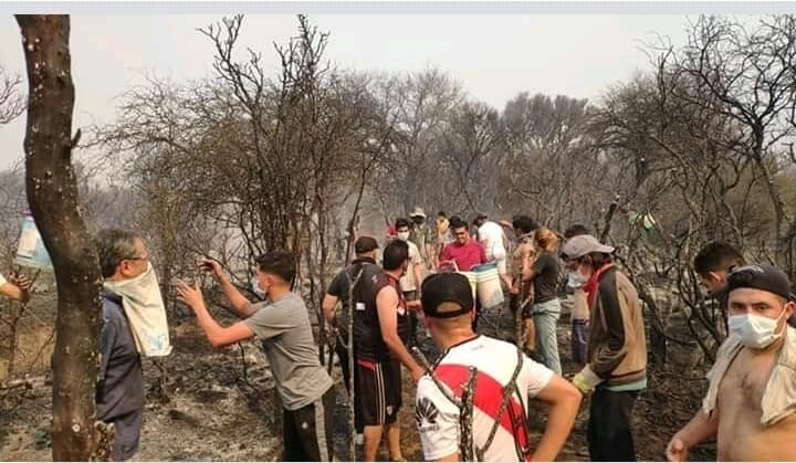 En Mina Clavero se formó un corredor humano de acarreo de agua para combatir los incendios. (Belen Intima)