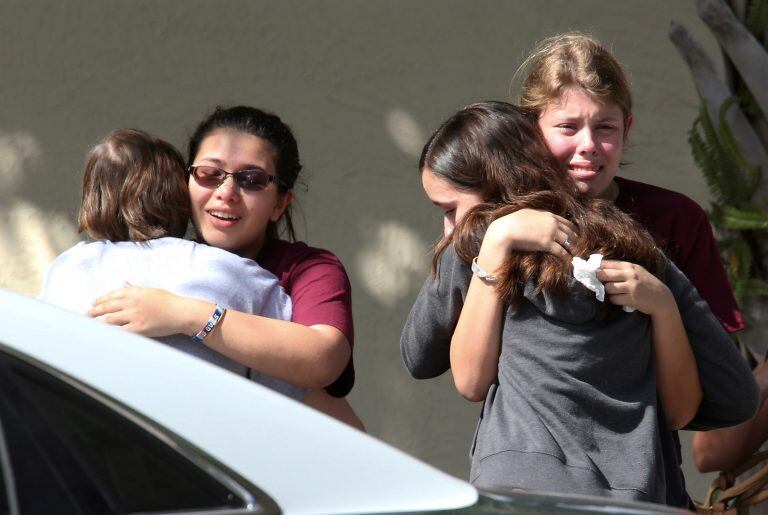 Students grieve outside Pines Trail Center where counselors are present, after Wednesday's mass shooting at Marjory Stoneman Douglas High School in Parkland, Fla., Thursday, Feb. 15, 2018.  Nikolas Cruz was charged with 17 counts of premeditated murder Thursday morning.  (AP Photo/Joel Auerbach)