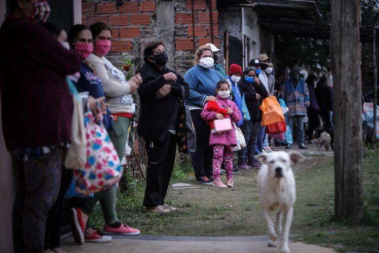 Personas esperan en una fila para recibir comida que reparten militares argentinos durante una jornada de la cuarentena obligatoria (EFE/Juan Ignacio Roncoroni)