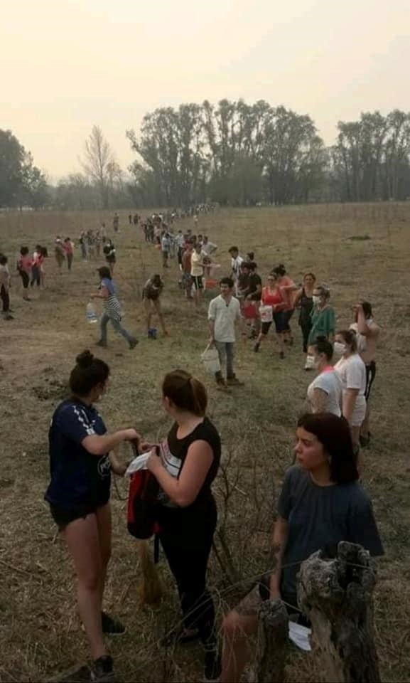 En Mina Clavero se formó un corredor humano de acarreo de agua para combatir los incendios. (Belen Intima)