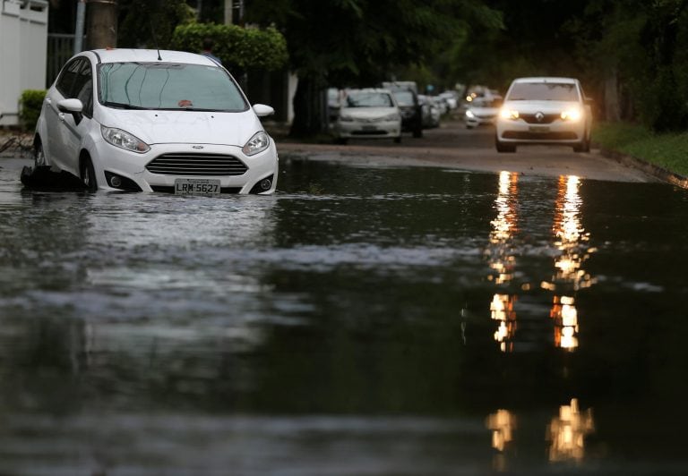 Varios autos fueron llevados por el agua. (REUTERS)