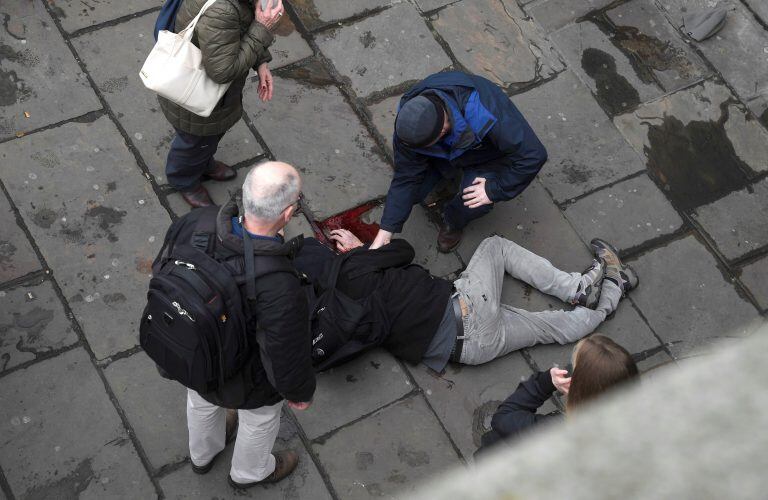 An injured man is assisted after an incident on Westminster Bridge in London, Britain March 22, 2017.  REUTERS/Toby Melville