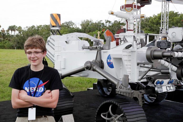 Alexander Mather, de 13 años, en Cabo Cañaveral, Florida, desde donde despegará la misión "Mars 2020", con "Perseverance". Alex fue el adolescente que ganó el concurso "Bautizá al robot", que la NASA organizó. 28 mil chicos participaron de la convocatoria. En la foto, se aprecia una maqueta del robot.