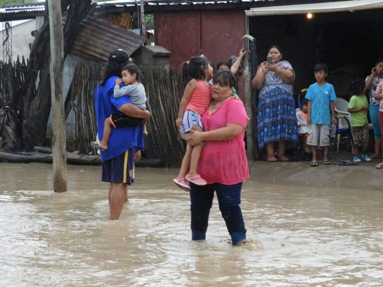 ARG01. SALTA (ARGENTINA), 02/02/2018.- Un grupo de personas permanece en una calle inundada hoy, viernes 2 de febrero de 2018, en la provincia de Salta (Argentina). Miles de personas fueron evacuadas hoy en la provincia norteña argentina de Salta debido a la fuerte crecida que experimentó el río Pilcomayo tras las intensas lluvias que sufre la zona desde comienzos de semana, informaron fuentes oficiales. EFE/--