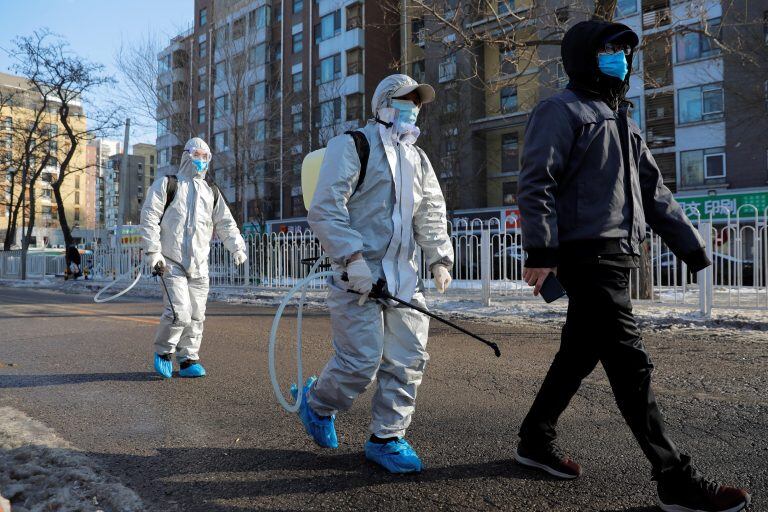 Trabajadores usan trajes protectores en China (Foto: Wu Hong/EFE)