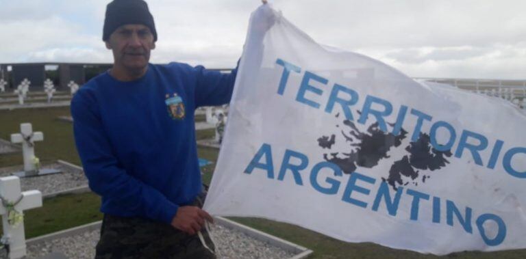 Escobedo con la bandera que lleva cada vez que va a Malvinas.