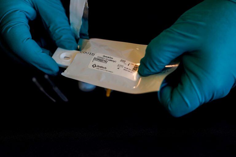 A picture taken on April 20, 2020, in Lieges, shows a technician carrying out a COVID-19 (novel coronavirus) serological test with a kit produced by Belgian biotechnical company ZenTech. (Photo by kenzo tribouillard / AFP)