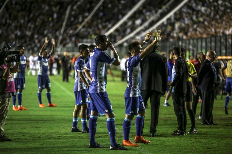 Jugadores de Racing piden calma a sus hinchas durante un enfrentamiento con la policía. (Foto: EFE/Antonio Lacerda)